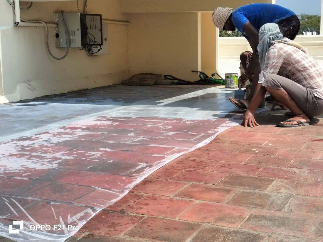 Technician applying waterproofing coating on site
